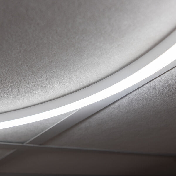 Close-up of illuminated round LED panel diffuser and ceiling edge